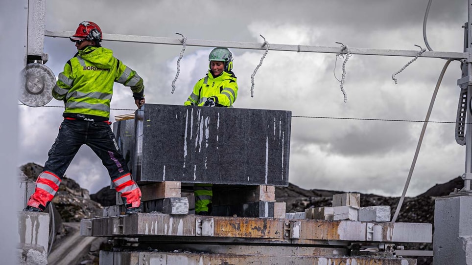 Bilde av to mennesker som opererer en blokksag.ererer en 